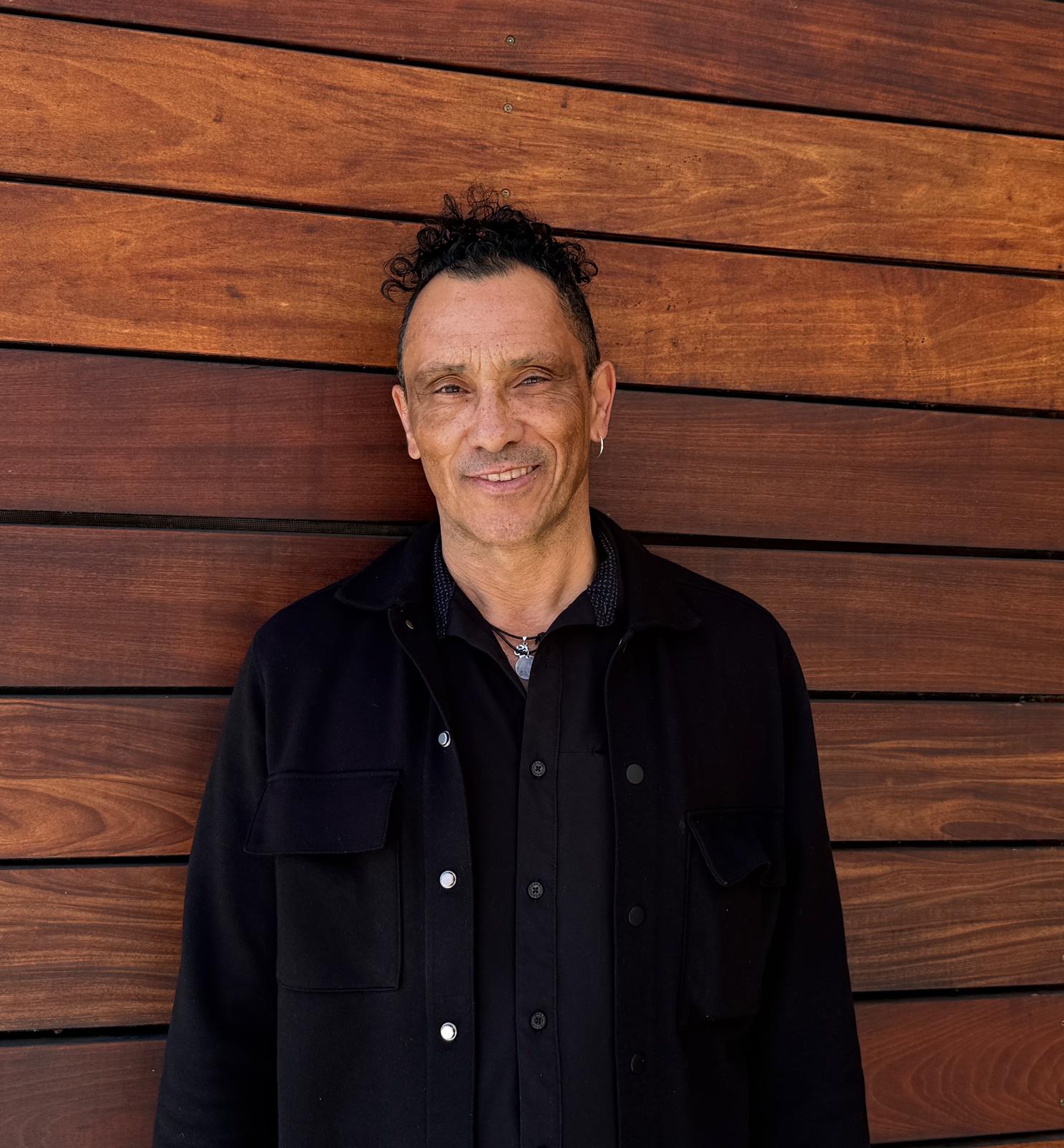 Glenn Marais standing in front of a warm wood wall